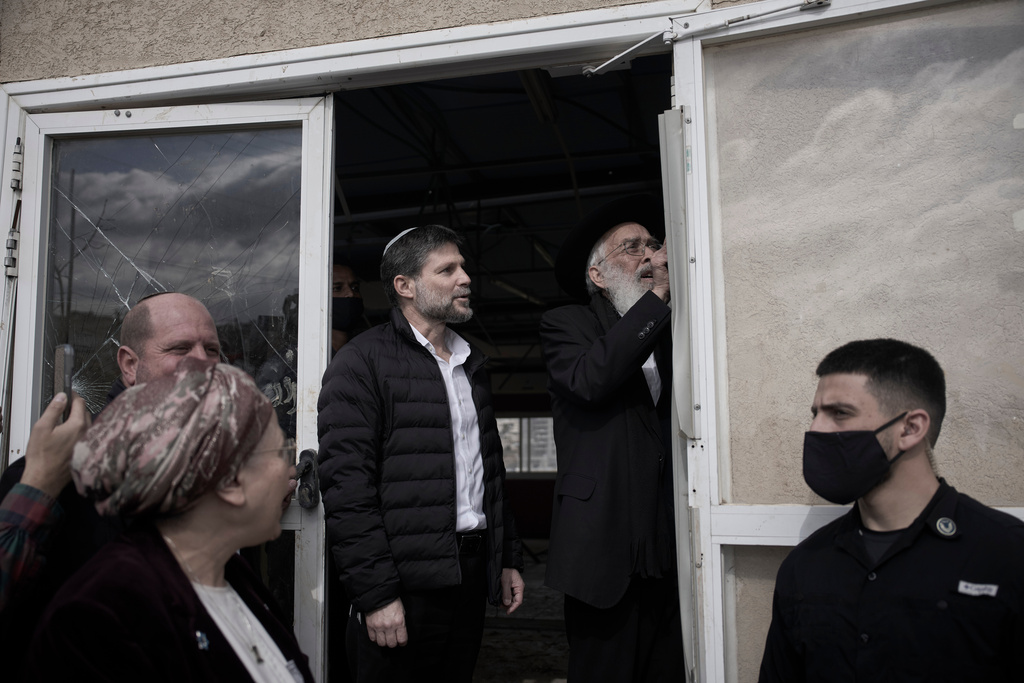 Israeli finance minister Bezalel Smotrich watches Rabbi Amiel Sternberg affix a mezuzah in the newly-legalized Jewish settlement, Yatziv, adjacent to the Palestinian town of Beit Sahour, in the West Bank, Monday, Jan. 19, 2026. (AP Photo/Ohad Zwigenberg)