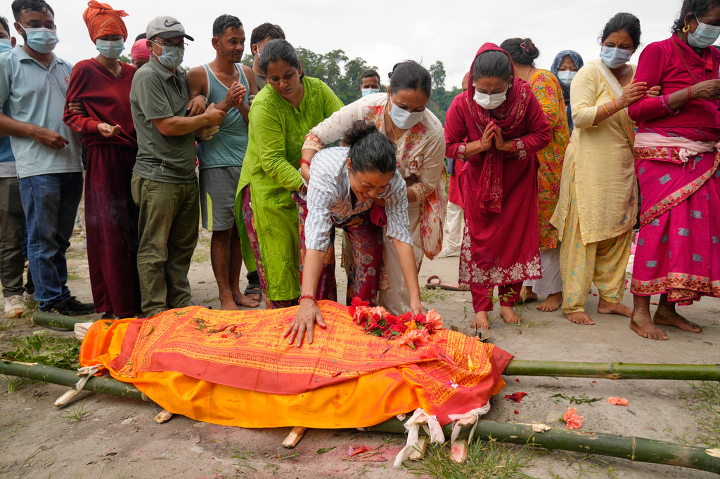 Muna Khadka, center, mother of Aayush Khadka, who was killed in flash floods, breaks down during her son's cremation in Chitwan, Nepal, Monday, Aug. 31, 2026. (AP Photo/Dar Yasin) CORRECTION: Corrects the second name of Aayush to Khadka instead of Khada.