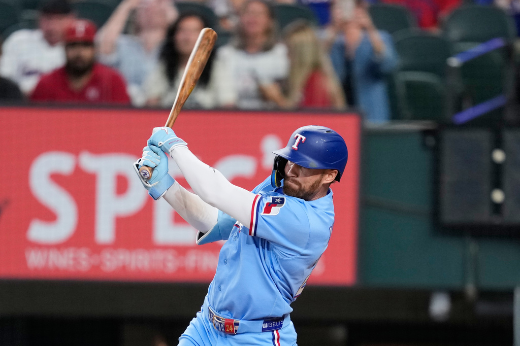 Texas Rangers' Brandon Nimmo follows through on a run-scoring single in the ninth inning of a baseball game against the Houston Astros in Arlington, Texas, Sunday, July 12, 2026. (AP Photo/Tony Gutierrez)