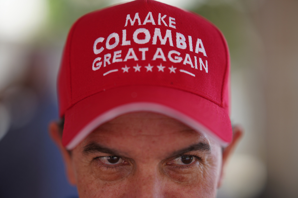 A voter wearing a "Make Colombia Great Again" cap waits in line during the runoff election in Barranquilla, Colombia, Sunday, June 21, 2026.(AP Photo/Ivan Valencia)
