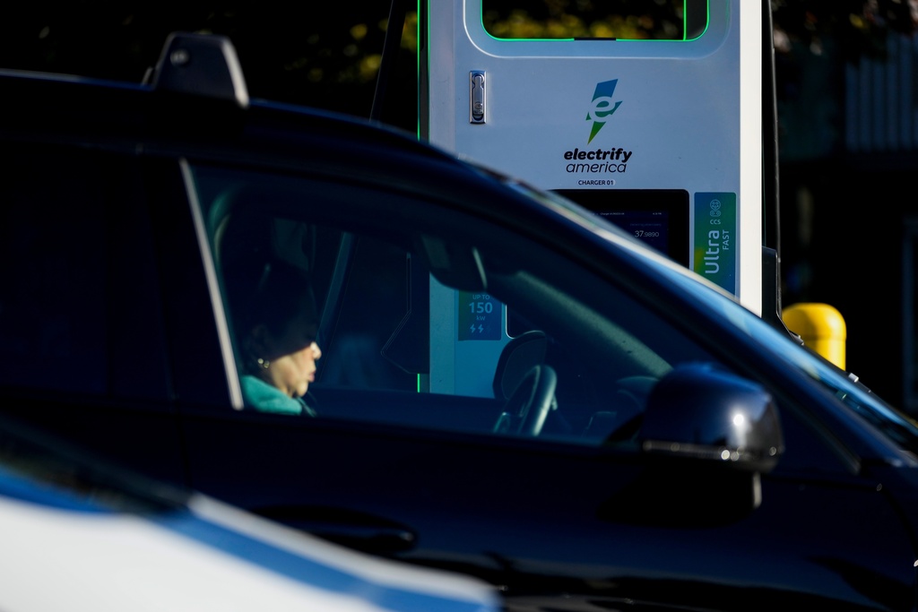FILE - A driver waits in their car while charging their electric vehicles at an Electrify America station Oct. 9, 2024, in Seattle. (AP Photo/Lindsey Wasson, File)