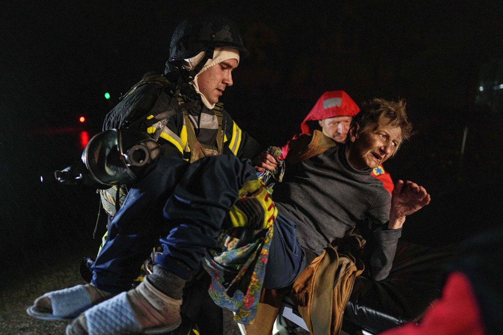 Rescuers carry an injured woman into an ambulance after a Russian strike on a residential neighborhood in Kyiv, Ukraine, on Friday, Oct. 10, 2025. (AP Photo/Evgeniy Maloletka)