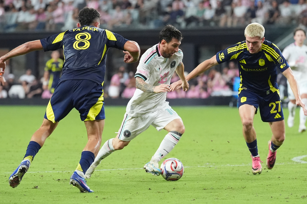 Nashville midfielder Patrick Yazbek (8) and defender Reed Baker-Whiting (27) defend Inter Miami forward Lionel Messi (10) during the second half of an MLS soccer match, Saturday, Sept. 12, 2026, in Miami. (AP Photo/Marta Lavandier)