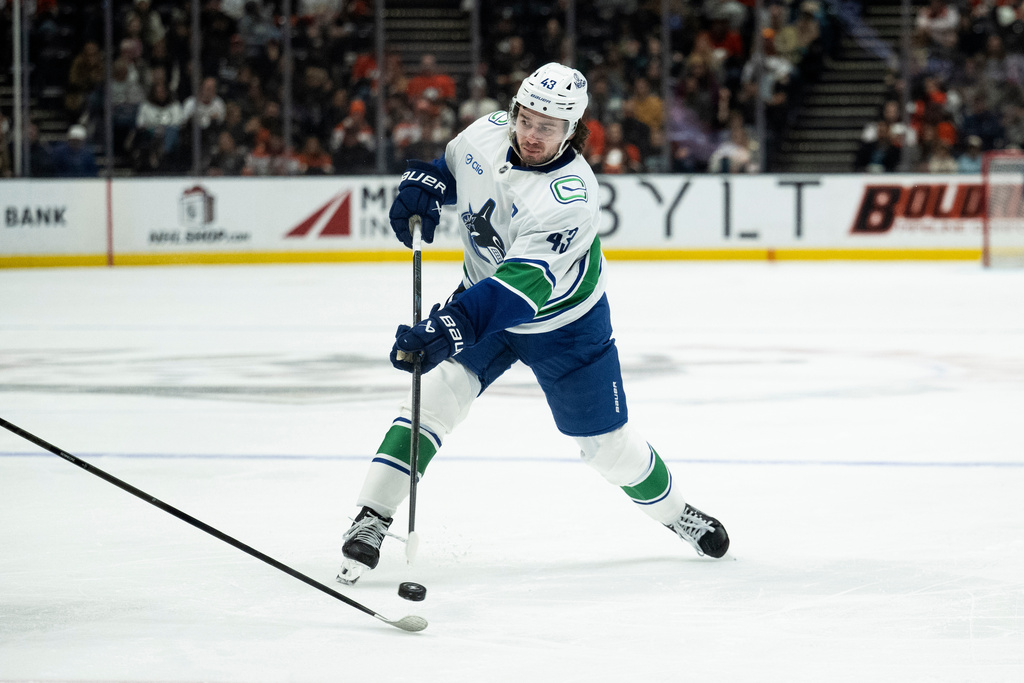 Vancouver Canucks defenseman Quinn Hughes (43) shoots during the second period of an NHL hockey game against the Anaheim Ducks, Wednesday, Nov. 26, 2025, in Anaheim, Calif. (AP Photo/Kyusung Gong)