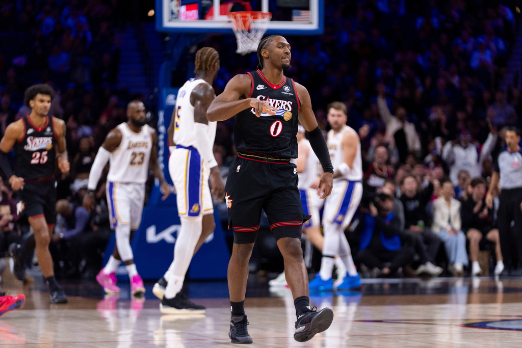 Philadelphia 76ers' Tyrese Maxey, center, reacts to his three-point shot during the first half of an NBA basketball game against the Los Angeles Lakers, Sunday, Dec. 7, 2025, in Philadelphia. (AP Photo/Chris Szagola)