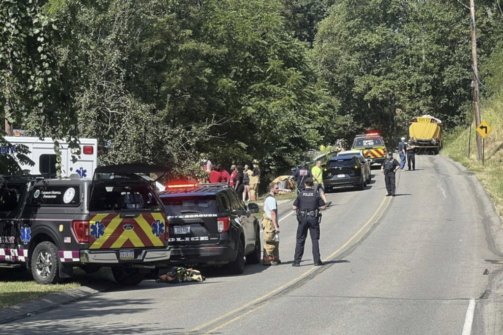 Emergency personnel work at the site of a crash of a bus carrying members of the Aliquippa Junior High School football team in Economy Bourough, Pa., on Saturday, Aug. 23, 2025. (Jessica Riley/KDKA-TV News via AP)