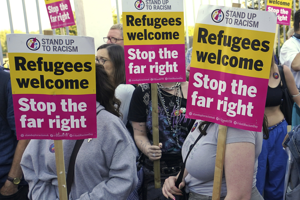 Protesters hold placards during a demonstration in Orpington near London, Friday, Aug. 22, 2025 as the dilemma of how to house asylum-seekers in Britain got more challenging for the government after a landmark court ruling this week motivated opponents to fight hotels used as accommodation.(AP Photo/Alberto Pezzali)
