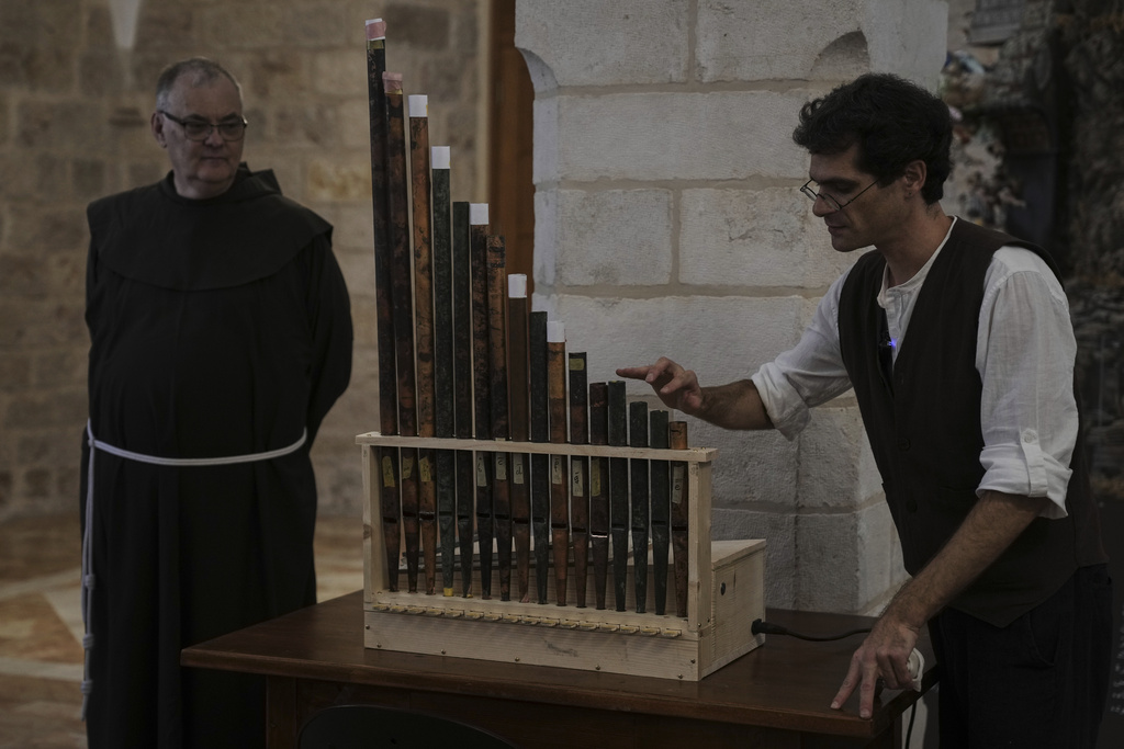 David Catalunya, a Valencian musician and musicologist displays an 11th-century organ that researchers say is the oldest in the Christian world was played for the first time in 800 years after restoration, in Saint Savior's Monastery of Jerusalem's Old City, Tuesday, Sept. 9, 2025. (AP Photo/Mahmoud Illean)