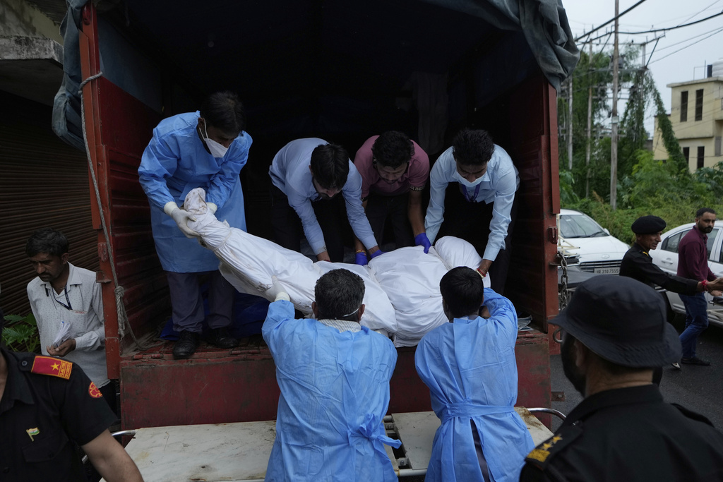 Health workers carry the body of a pilgrim who died in a landslide due to floods on the route to the Shri Mata Vaishno Devi Temple, being shifted to the Government Medical Hospital in Jammu, India, Wednesday, Aug. 27, 2025.(AP Photo/Channi Anand)