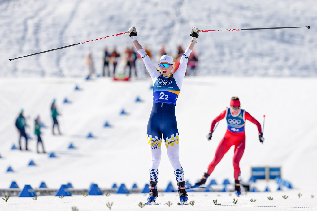 Maja Dahlqvist, of Sweden, crosses the finish line to win the gold medal, ahead of Nadine Faehndrich, of Switzerland, in the cross-country skiing women's team sprint free at the 2026 Winter Olympics, in Tesero, Italy, Wednesday, Feb. 18, 2026. (AP Photo/Kirsty Wigglesworth)