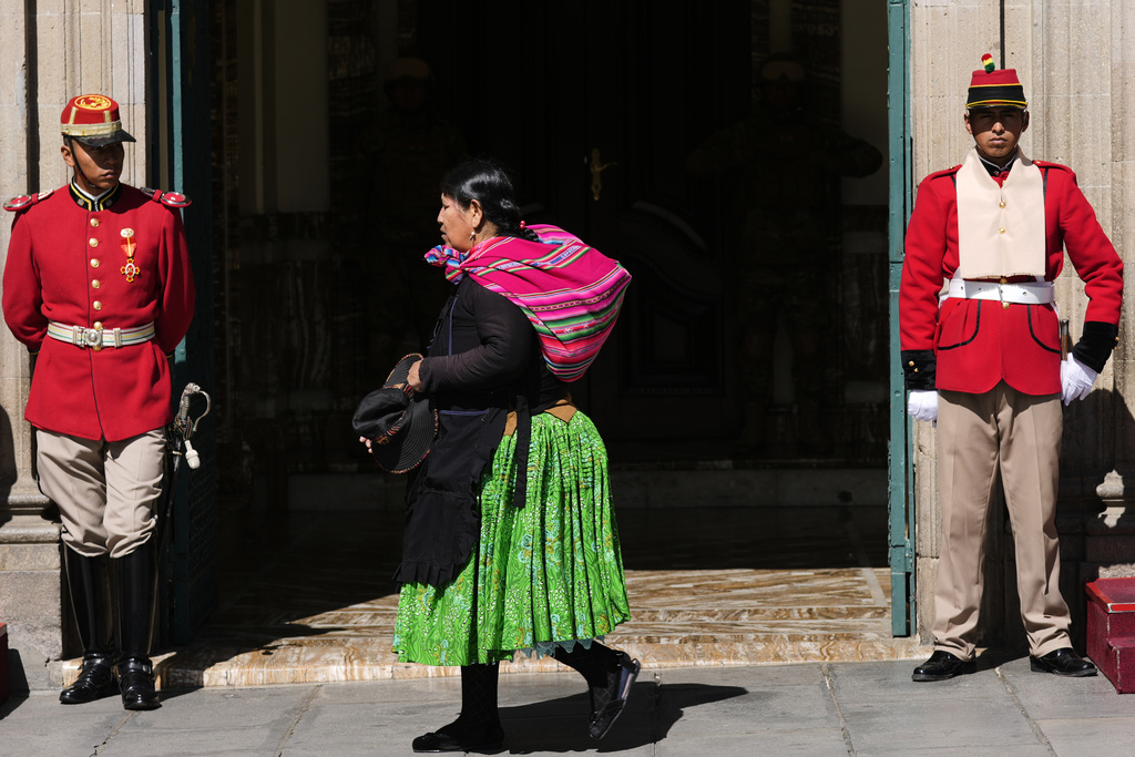 A woman walks past the government palace in La Paz, Bolivia, Monday, Aug. 18, 2025, the day after the presidential election which is headed to a runoff. (AP Photo/Juan Karita)