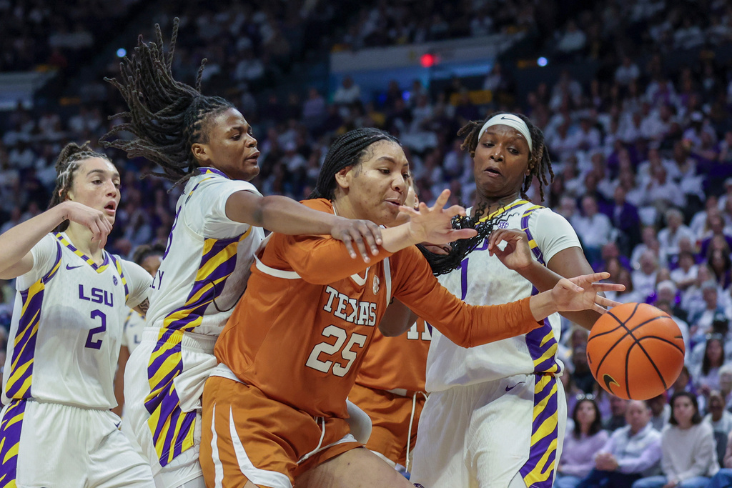 LSU guard MiLaysia Fulwiley, second from left, and Texas forward Breya Cunningham (25) both go after the ball in the first half of an NCAA college basketball game in Baton Rouge, La., Sunday, Jan. 11, 2026. (AP Photo/Peter Forest)