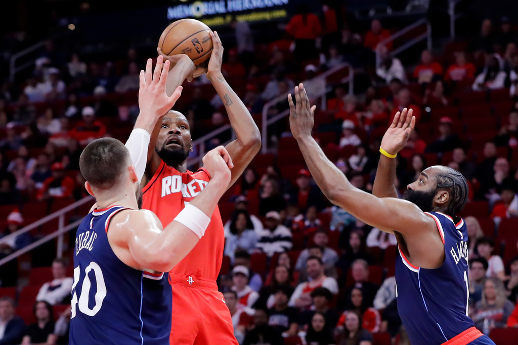 Houston Rockets forward Kevin Durant, center, shoots the ball betwen LA Clippers center Ivica Zubac, left, and guard James Harden, right, during the first half of an NBA basketball game Thursday, Dec. 11, 2025, in Houston. (AP Photo/Michael Wyke)