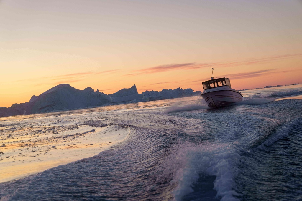 A fishing boat rides in front of an iceberg at Disko Bay near Ilulissat, Greenland, on Wednesday, Jan. 28, 2026. (AP Photo/Evgeniy Maloletka)