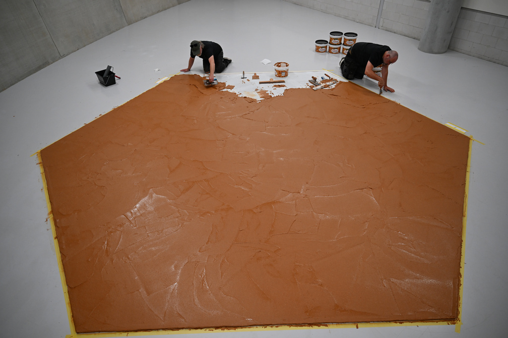 Workers spread peanut butter on a floor to recreate the "Peanut Butter Floor" artwork in tribute to Dutch artist Wim T. Schippers at the Museum Boijmans Van Beuningen in Rotterdam, Netherlands, Friday, July 3, 2026. (AP Photo/Mouneb Taim)