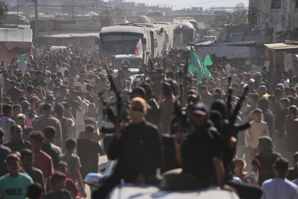Hamas gunmen in escort buses carrying freed Palestinian prisoners arriving in the Gaza Strip after their release from Israeli jails under a ceasefire agreement between Hamas and Israel, in Khan Younis, southern Gaza Strip, Monday, Oct. 13, 2025. (AP Photo/Jehad Alshrafi)