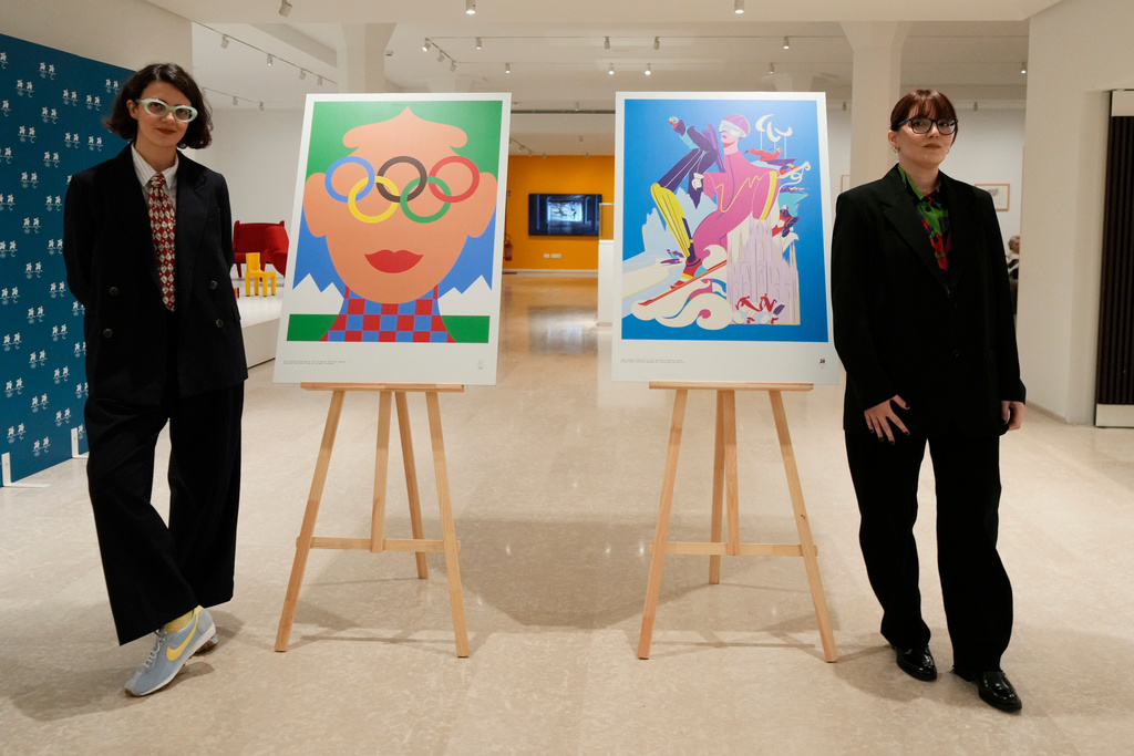 Artists Olimpia Zagnoli, left, and Carolina Altavilla pose next to Milano-Cortina 2026 Winter Olympics iconic posters presented during a press conference at Milan's Triennale permanent exhibition in Milan, Italy, Wednesday, Oct. 22, 2025. (AP Photo/Luca Bruno)