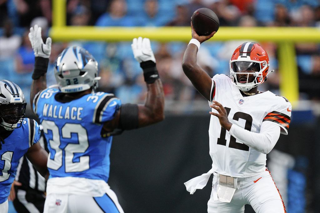 Cleveland Browns quarterback Shedeur Sanders passes over Carolina Panthers linebacker Trevin Wallace during the first half of a preseason NFL football game on Friday, Aug. 8, 2025, in Charlotte, N.C. (AP Photo/Jacob Kupferman)