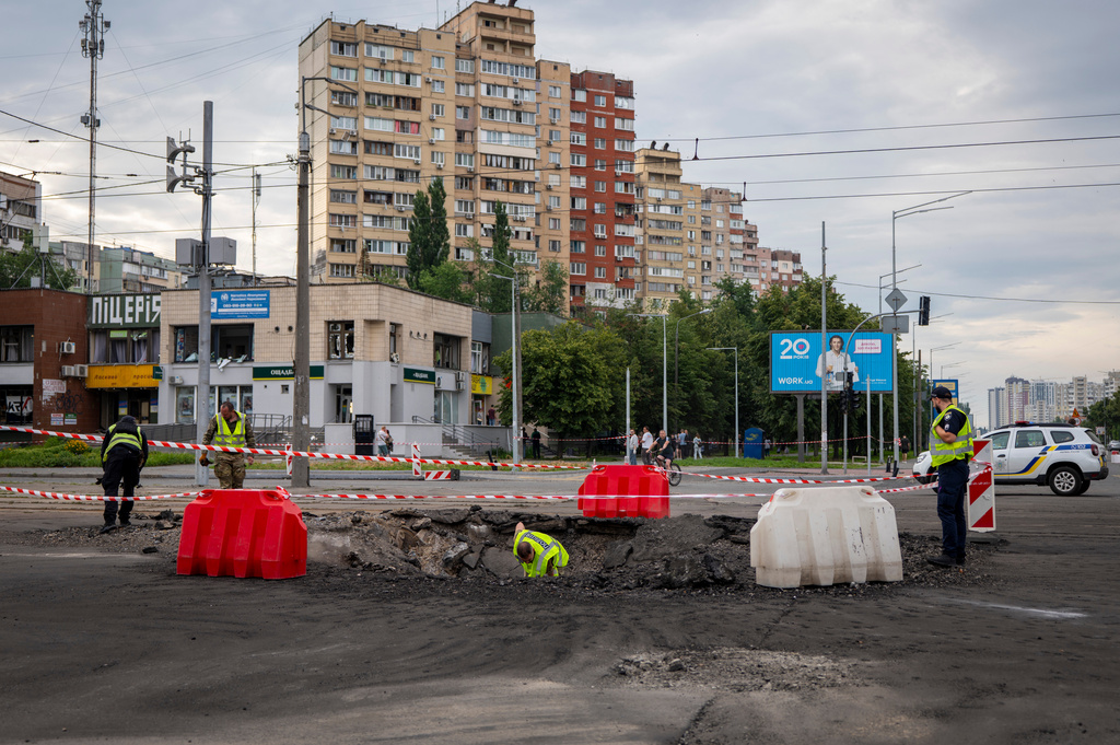 A sapper examines the impact site of a Russian missile in a residential area of Kyiv, Saturday, July 11, 2026. (AP Photo/Dan Bashakov)