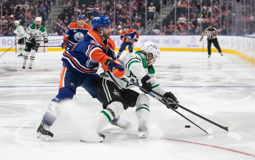 Dallas Stars' Sam Steel (18) and Edmonton Oilers' Darnell Nurse (25) battle for the puck during third period NHL action, in Edmonton on Tuesday Nov. 25, 2025. (Jason Franson/The Canadian Press via AP)