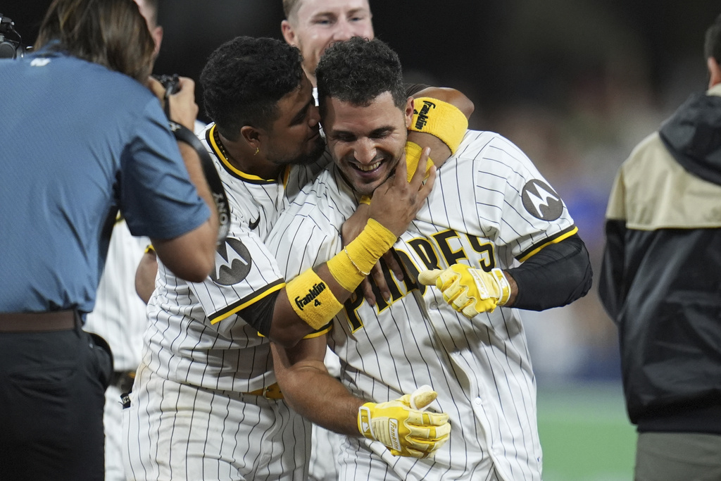 San Diego Padres' Ramon Laureano, right, is embraced by teammate first baseman Luis Arraez after Laureano hit a walk-off RBI single during the tenth inning of a baseball game Saturday, Aug. 9, 2025, in San Diego. The Padres won 5-4. (AP Photo/Gregory Bull)