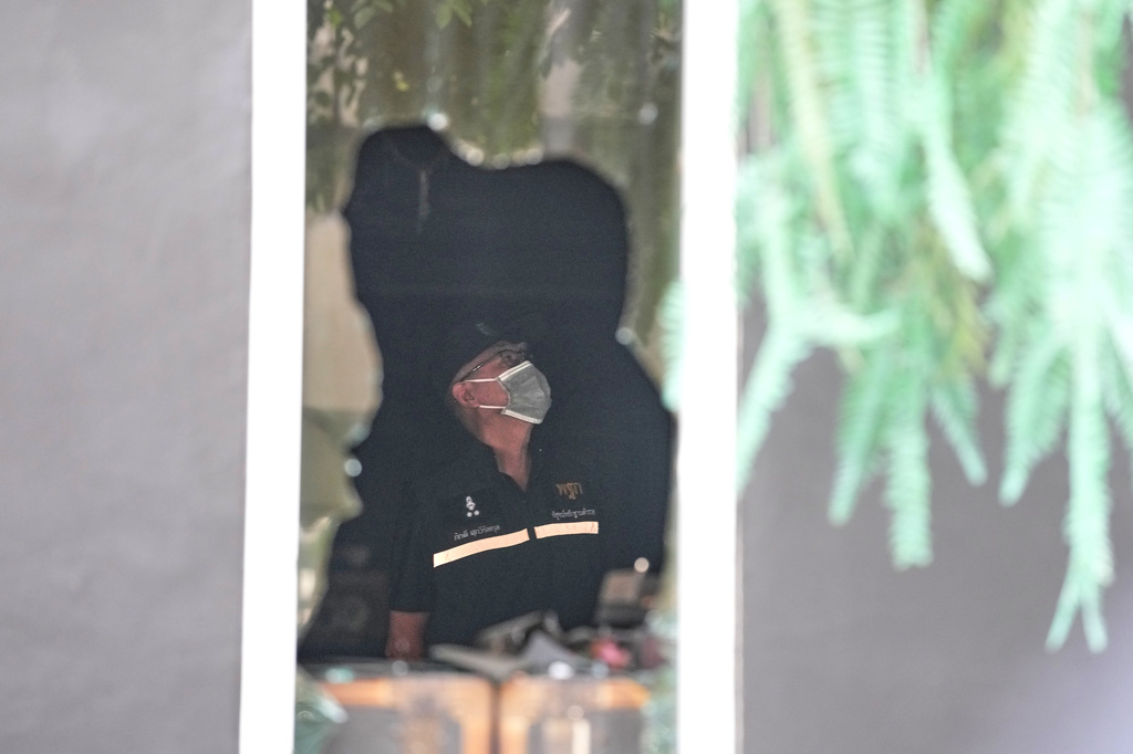 A forensic police officer inspects the site of a fire in Bangkok, Thailand, Monday, July 13, 2026. (AP Photo/Sakchai Lalit)