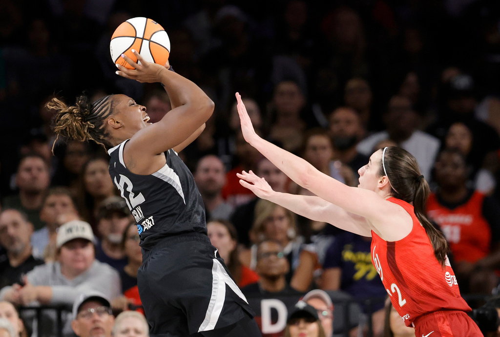 Las Vegas Aces guard Chelsea Gray (12) shoots over Indiana Fever guard Caitlin Clark (22) during the first half of an WNBA basketball game Sunday, July 12, 2026, in Las Vegas. (Steve Marcus/Las Vegas Sun via AP)