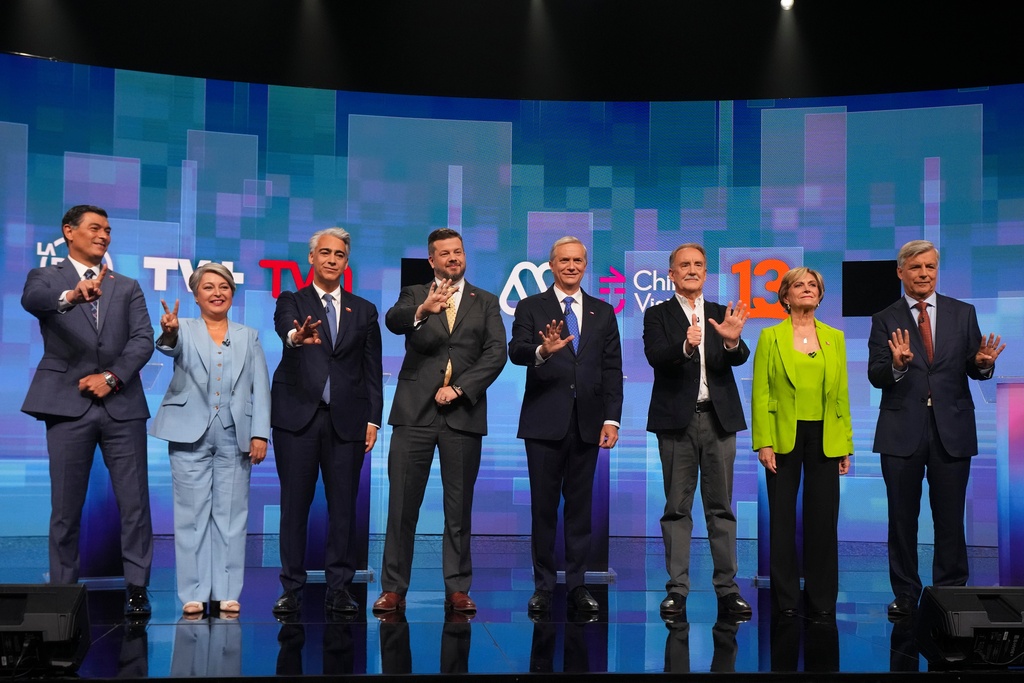 From left, presidential candidates Franco Parisi of the Party of the People, Jeannette Jara of the Unidad por Chile coalition, Marco Enriquez-Ominami of the Progressive Party, Johannes Kaiser of the National Libertarian Party, Jose Antonio Kast of the Republican Party, Eduardo Artes of the Proletarian Action Party, Evelyn Matthei of the Chile Vamos coalition and Independent Harold Mayne-Nicholls gesture prior to a debate ahead of the November general elections, in Santiago, Chile, Monday, Nov. 10, 2025. (AP Photo/Esteban Felix)
