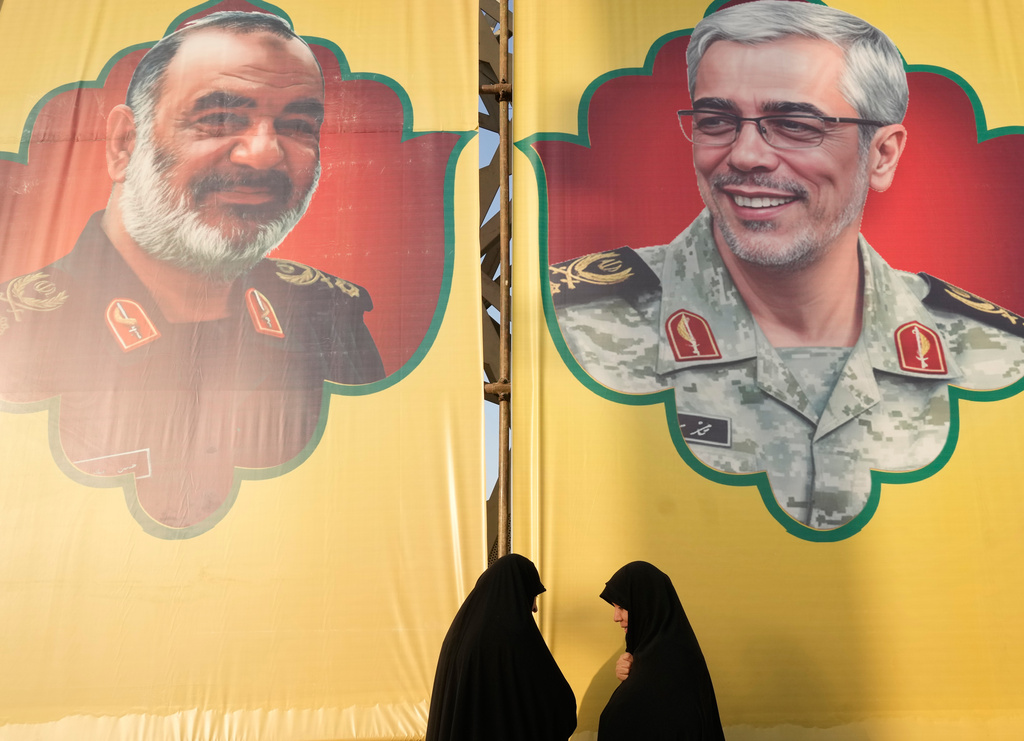 Women talk in front of the banners showing portraits of the late chief of the general staff of Iran's armed forces, Gen. Mohammad Hossein Bagheri, right, and the late commander of Revolutionary Guard Gen. Hossein Salami, who were killed in Israeli strike in June, during a commemoration marking the first death anniversary of Hezbollah leaders Hassan Nasrallah and Hashem Safieddine, who were killed in Israeli airstrikes in Beirut, in Tehran, Iran, Thursday, Oct. 2, 2025. (AP Photo/Vahid Salemi)