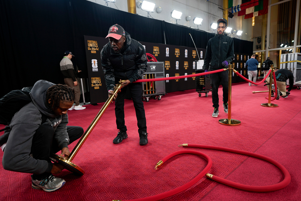 Workers prepare the red carpet area prior to the final draw for the 2026 soccer World Cup at the Kennedy Center in Washington, Thursday, Dec. 4, 2025. (AP Photo/Chris Carlson)