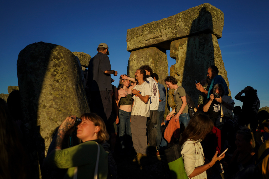Revelers gather at the ancient stone circle Stonehenge to celebrate the summer solstice, the longest day of the year, near Salisbury, England, on Saturday, June 20, 2026. (AP Photo/Alberto Pezzali)