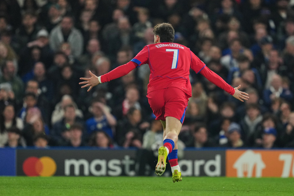 PSG's Khvicha Kvaratskhelia celebrates after scoring his side's opening goal during the Champions League soccer match between Chelsea and Paris Saint-Germain in London, England, Tuesday, March 17, 2026. (AP Photo/Kin Cheung)