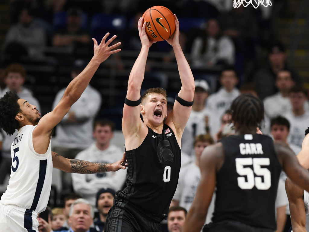 Michigan State's Coen Carr (55) watches as teammate Jaxon Kohler (0) pulls down a rebound away from Penn State's Freddie Dilione V (5) during the first half of an NCAA college basketball game Saturday, Dec. 13, 2025, in State College, Pa. (AP Photo/Gary M. Baranec)