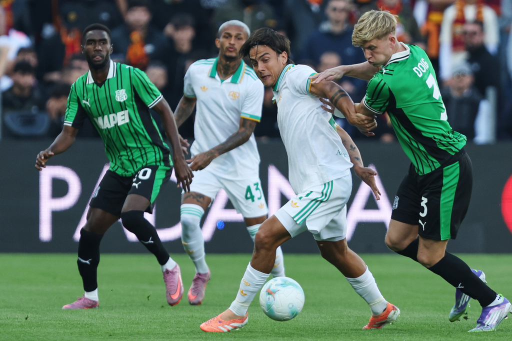 Roma's Paulo Dybala is challenged by Sassuolo's Josh Doig, right, during the Serie A soccer match between Sassuolo and Roma, in Reggio Emilia, Italy, Sunday, Oct. 26, 2025. (Gianni Santandrea/LaPresse via AP)