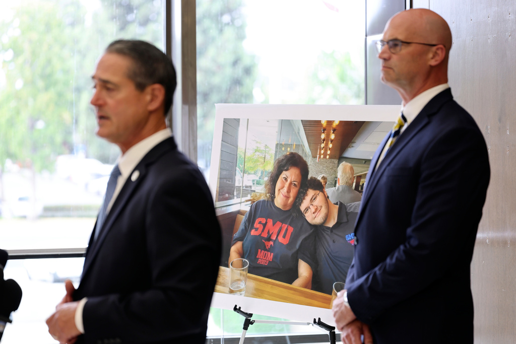 A photo of Sheryl Ferguson, the wife and son Phillip Ferguson of Orange County Superior Judge Jeffrey Ferguson is displayed as Orange County District Attorney Todd Spitzer, left, and Senior Deputy District Attorneys Seton Hunt speak to the media after Orange County Superior Court Judge Jeffrey Ferguson was sentenced to 35 years to life in prison after his second-degree murder conviction for shooting his wife, at the Central Justice Center in Santa Ana, Calif., Wednesday, Sept. 17, 2025. (Allen J. Schaben/Los Angeles Times via AP, Pool)