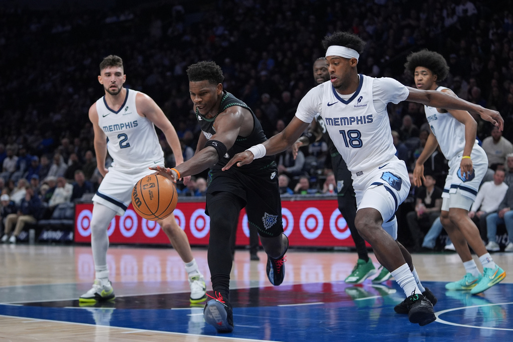 Minnesota Timberwolves guard Anthony Edwards, middle, reaches for the ball against Memphis Grizzlies forward Olivier-Maxence Prosper (18) during the first half of an NBA basketball game, Tuesday, March 3, 2026, in Minneapolis. (AP Photo/Abbie Parr)