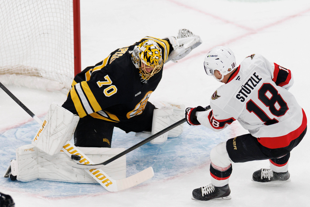 Boston Bruins goaltender Joonas Korpisalo (70) blocks a shot by Ottawa Senators' Tim Stützle (18) during the first period of an NHL hockey game in Boston, Sunday, Dec. 21, 2025. (AP Photo/CJ Gunther)