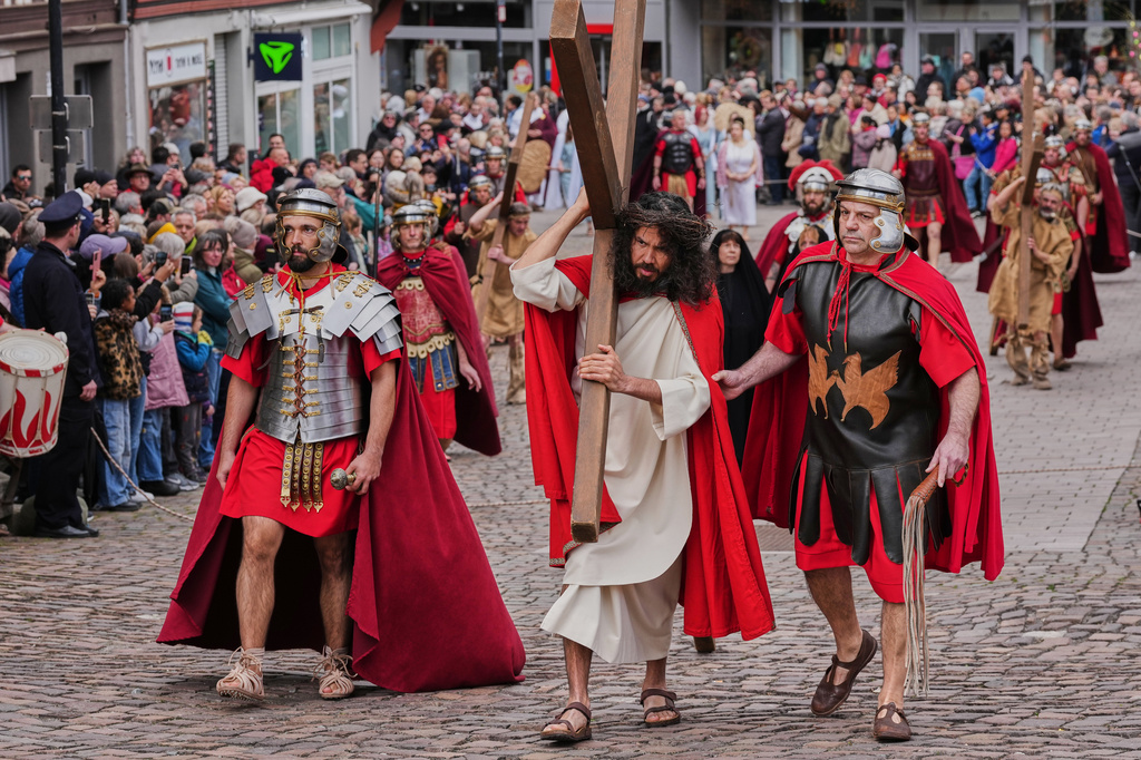 An amateur actor performing as Jesus carries the cross during the traditional Good Friday procession organised by the Italian community in Bensheim, Germany, Friday, April 3, 2026. (AP Photo/Michael Probst)