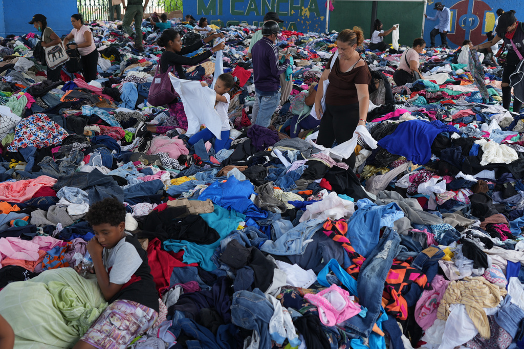 People choose clothes donated to those affected by the earthquakes at a sports complex in La Guaira, Venezuela, Saturday, July 4, 2026. (AP Photo/Ariana Cubillos)