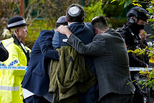 Members of the Jewish community comfort each other near to the Heaton Park Hebrew Congregation synagogue, in Crumpsall, Manchester, England, Thursday, Oct. 2, 2025 after Police reported that two people were killed and three others were seriously injured in a synagogue attack in northern England. (Peter Byrne/PA via AP) Members of the Jewish community comfort each other near to the Heaton Park Hebrew Congregation synagogue, in Crumpsall, Manchester, England, Thursday, Oct. 2, 2025 after Police reported that two people were killed and three others were seriously injured in a synagogue attack in northern England. (Peter Byrne/PA via AP)