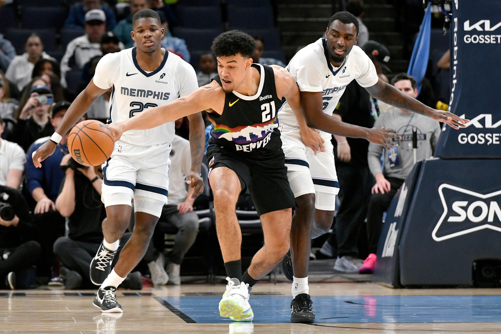 Denver Nuggets forward Spencer Jones (21) reaches for the ball ahead of Memphis Grizzlies forward Cedric Coward and guard Vince Williams Jr. in the first half of an NBA basketball game, Monday, Nov. 24, 2025, in Memphis, Tenn. (AP Photo/Brandon Dill)