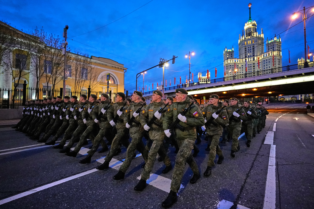 Russian servicemen march towards Red Square prior to the Victory Day military parade rehearsal in Moscow, Wednesday, April 29, 2026, backdropped by a Stalin stile skyscraper. (AP Photo/Alexander Zemlianichenko)