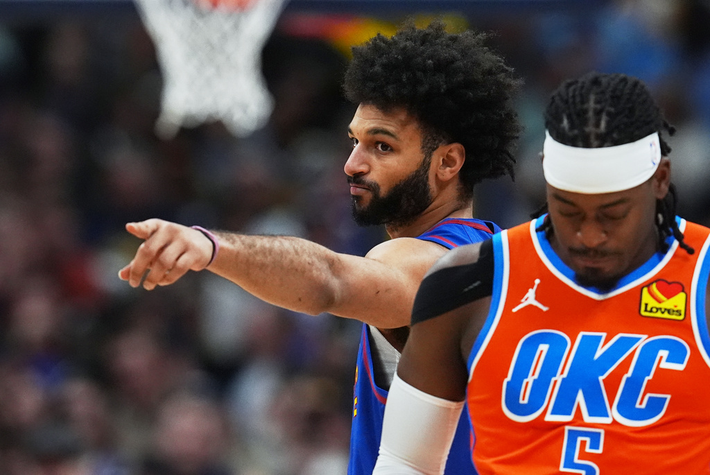 Denver Nuggets guard Jamal Murray, back, gestures as Oklahoma City Thunder guard Luguentz Dort prepares for tip off in the first half of an NBA basketball game, Sunday, Feb. 1, 2026, in Denver. (AP Photo/David Zalubowski)