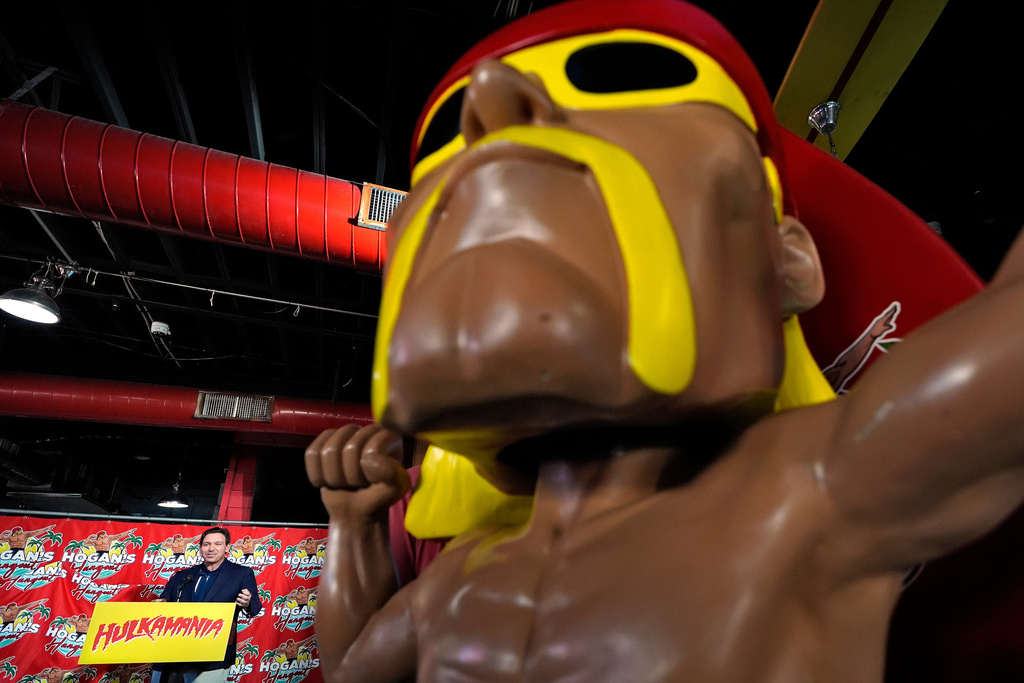 Florida Gov. Ron DeSantis, lower left, speaks near a statue of Hulk Hogan after naming a trail in honor of the wrestling legend during a news conference Friday, Oct. 3, 2025, in Clearwater, Fla. (AP Photo/Chris O'Meara)