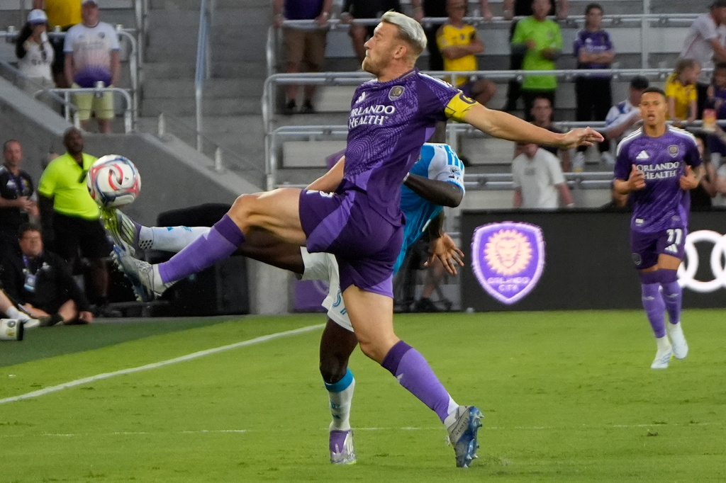 Orlando City SC defender Robin Jansson, front, tries to control the ball in front of Charlotte FC forward Rodolfo Aloko during the first half of an MLS soccer match, Wednesday, April 22, 2026, in Orlando, Fla. (AP Photo/John Raoux)