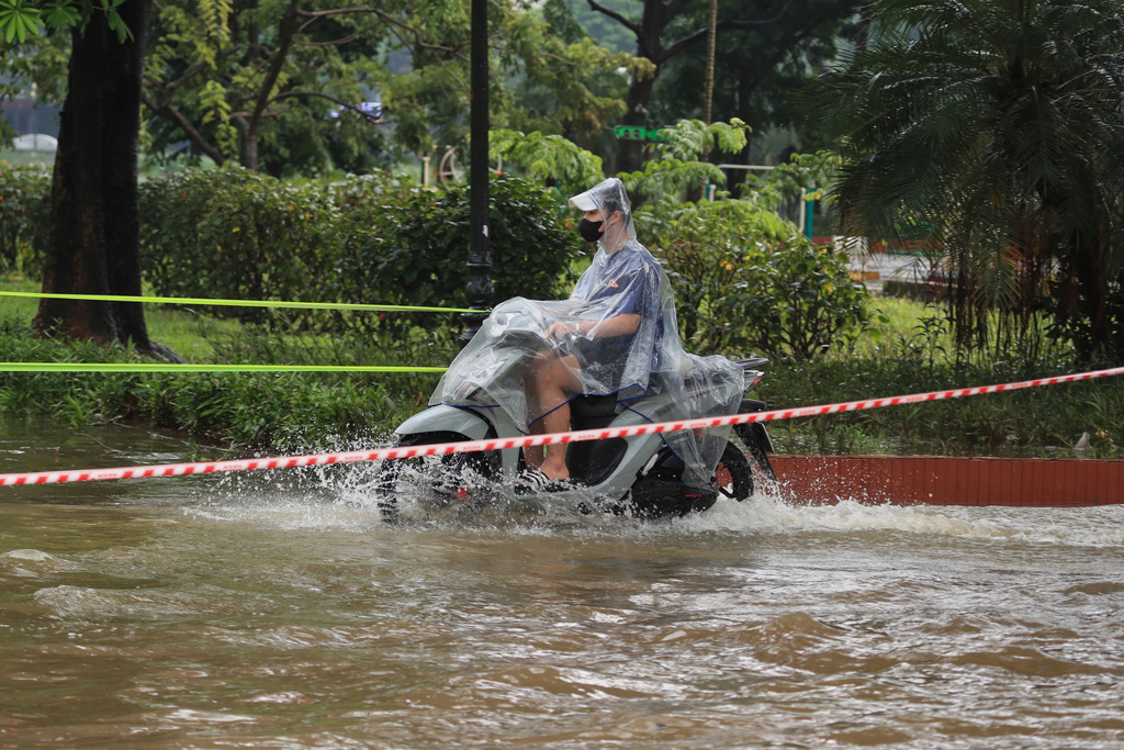 A man rides a motorcycle on a flooded street caused by Typhoon Kajiki in Hanoi, Vietnam, Tuesday, Aug. 26, 2025. (AP Photo/Huy Han)