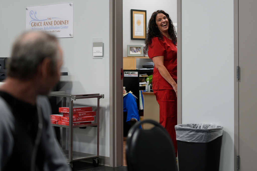 Roger James, a former coal miner and black lung patient, left, looks at Lisa Emery, director of the New River Health Association Black Lung Clinic, at the clinic on Sept. 24, 2025, in Oak Hill, W.Va. (AP Photo/Carolyn Kaster)