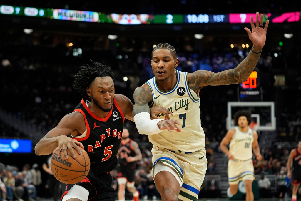 Toronto Raptors' Immanuel Quickley (5) drives to the basket against Milwaukee Bucks' Kevin Porter Jr. (7) during the first half of an NBA basketball game Thursday, Dec. 18, 2025, in Milwaukee. (AP Photo/Aaron Gash)