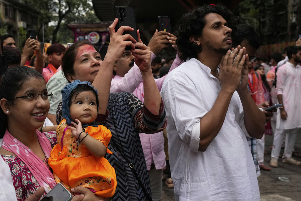 People watch as an idol of elephant-headed Hindu god Ganesha is taken for immersion on the final day of the ten-day long Ganesh Chaturthi festival in Mumbai, India, Saturday, Sept. 6, 2025. (AP Photo/Rajanish Kakade)