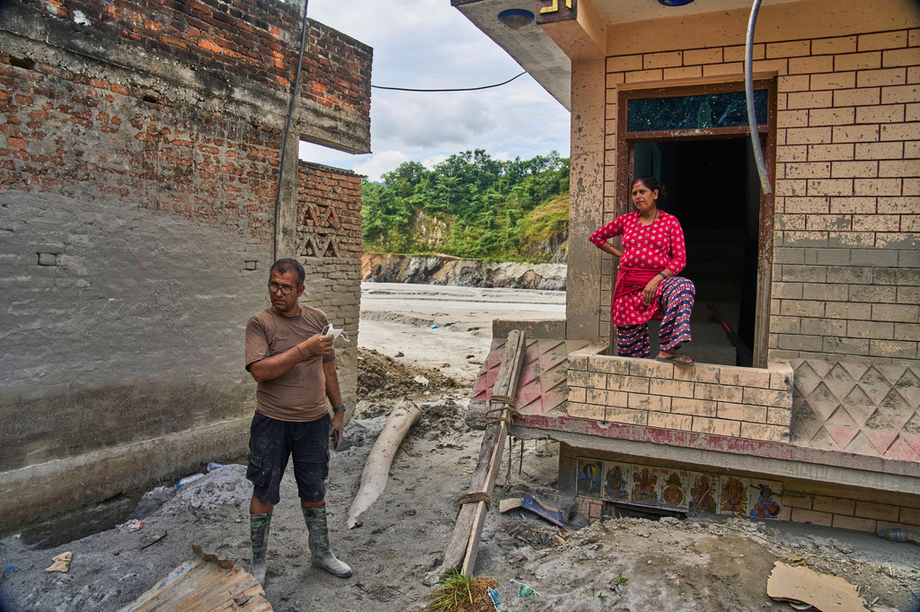 Narayan Prasad Nepal, left, stands outside his damaged house by a flash flood in Galchi, Nuwakot, Nepal, Wednesday, Sept. 23, 2026. (AP Photo/Niranjan Shrestha)